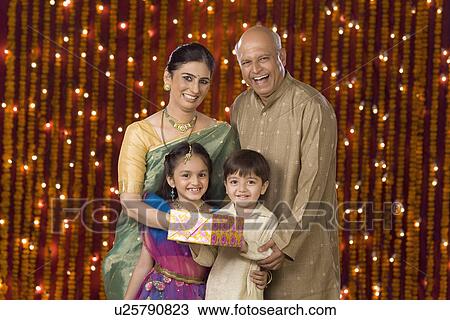 Couple with grandchildren holding Diwali gift View Large Photo Image Stock Image - Couple with grandchildren holding Diwali gift. Fotosearch