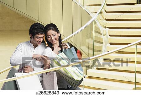 Stock Photo - Couple with shopping bags in a shopping mall. Fotosearch