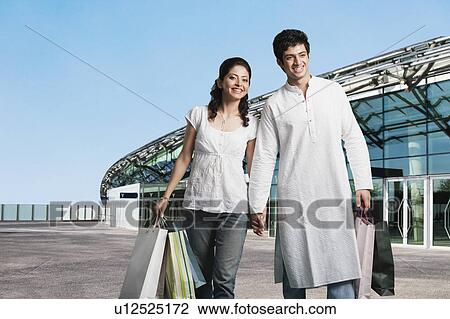 Couple with shopping bags outside a shopping mall View Large Photo Image Stock Image - Couple with shopping bags outside a shopping mall. Fotosearch