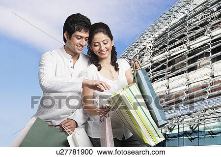 Stock Image - Couple with shopping bags outside a shopping mall. Fotosearch