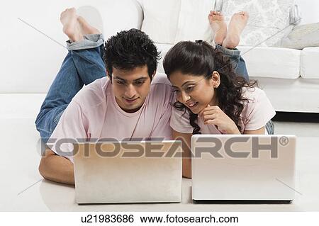 Couple working on laptops View Large Photo Image Stock Photograph - Couple working on laptops. Fotosearch