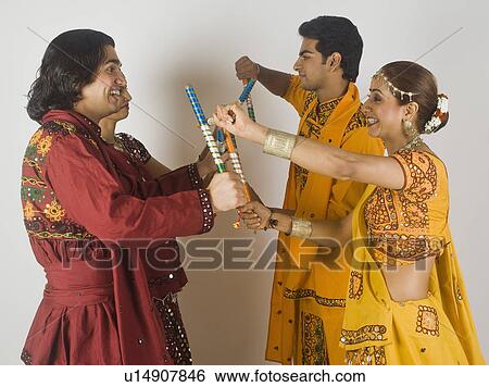 Couples performing dandiya View Large Photo Image Stock Photograph - Couples performing dandiya. Fotosearch