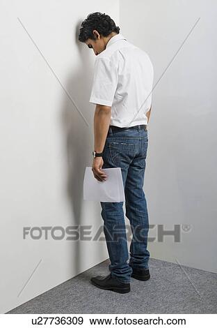 Stock Photo - Disappointed man leaning head against wall. Fotosearch