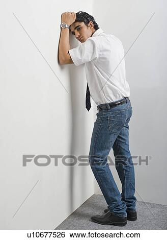 Stock Photograph - Disappointed university student leaning his head on the wall in the corner. Fotosearch