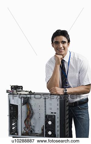 Stock Photo - Engineering student standing with a computer cabinet. Fotosearch