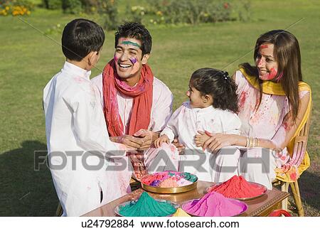 Picture - Family celebrating Holi in a garden. Fotosearch