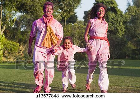 Stock Photo - Family celebrating Holi in a garden. Fotosearch