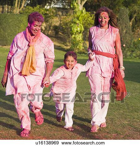 Stock Photo - Family celebrating Holi in a garden. Fotosearch