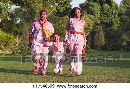 Stock Photo - Family celebrating Holi in a garden. Fotosearch