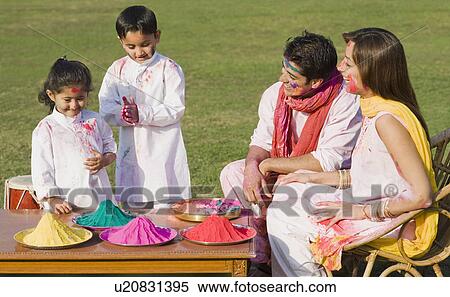 Stock Photography - Family celebrating Holi in a garden. Fotosearch