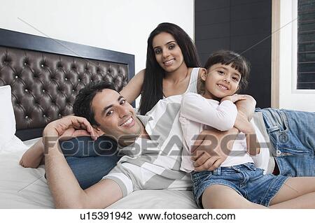 Stock Image - Family enjoying in a bedroom. Fotosearch