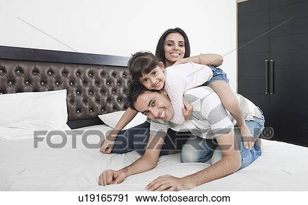 Stock Image - Family enjoying in a bedroom. Fotosearch