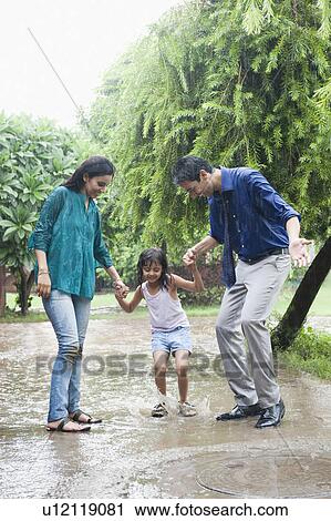 Family enjoying in rain in a park View Large Photo Image Stock Image - Family enjoying in rain in a park. Fotosearch