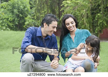 Family enjoying in rain in a park View Large Photo Image Stock Image - Family enjoying in rain in a park. Fotosearch