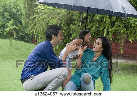 Family enjoying in rain in a park View Large Photo Image Stock Photo - Family enjoying in rain in a park. Fotosearch