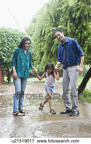 Family enjoying in rain in a park View Large Photo Image Stock Photo - Family enjoying in rain in a park. Fotosearch