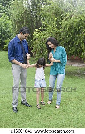 Stock Photography - Family enjoying in rain in a park. Fotosearch