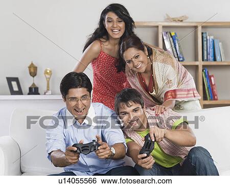 Family playing video game at home View Large Photo Image Stock Photograph - Family playing video game at home. Fotosearch