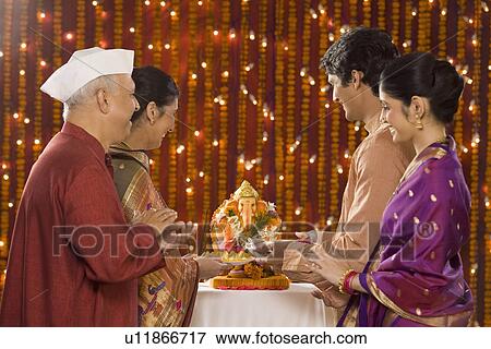 Family standing in front of the idol of lord Ganesha View Large Photo Image Stock Photo - Family standing in front of the idol of lord Ganesha. Fotosearch
