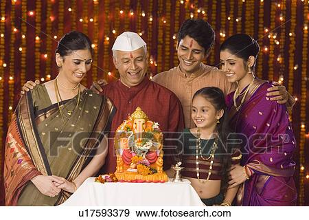 Stock Photo - Family standing in front of the idol of lord Ganesha. Fotosearch