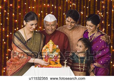 Family standing in front of the idol of lord Ganesha View Large Photo Image Stock Photography - Family standing in front of the idol of lord Ganesha. Fotosearch