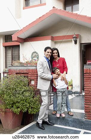 Stock Photography - Family standing in front of their house. Fotosearch