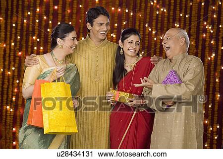 Stock Image - Family with shopping bags and Diwali gift. Fotosearch