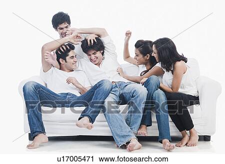 Stock Image - Friends having fun on a couch. Fotosearch