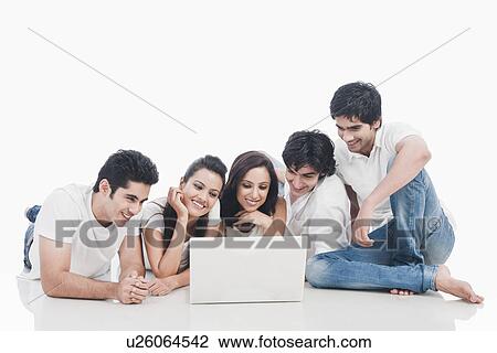 Stock Image - Friends looking at a laptop. Fotosearch