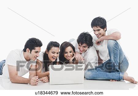 Friends looking at a laptop View Large Photo Image Stock Photo - Friends looking at a laptop. Fotosearch