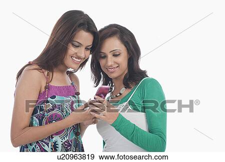Friends reading SMS on a mobile phone View Large Photo Image Stock Photo - Friends reading SMS on a mobile phone. Fotosearch