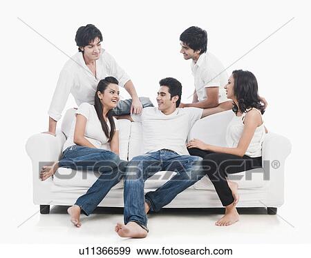 Friends sitting on a couch and smiling View Large Photo Image Stock Photo - Friends sitting on a couch and smiling. Fotosearch