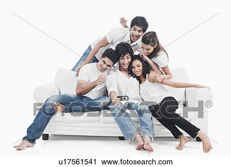 Friends taking picture of themselves with a mobile phone View Large Photo Image Stock Image - Friends taking picture of themselves with a mobile phone. Fotosearch