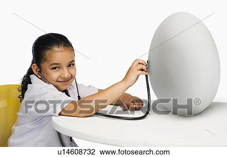 Stock Image - Girl examining a egg with a stethoscope. Fotosearch