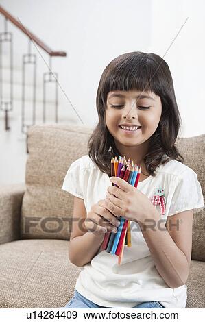 Stock Photo - Girl holding colored pencils. Fotosearch