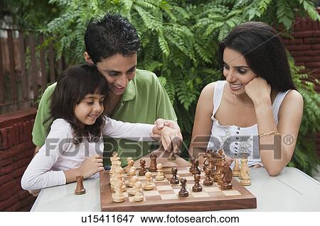 Stock Photo - Girl playing chess with her parents. Fotosearch