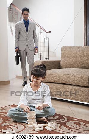 Girl playing Jenga with her father standing in the background View Large Photo Image Stock Photo - Girl playing Jenga with her father standing in the background. Fotosearch