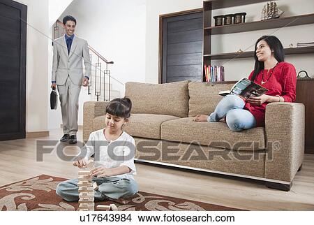 Girl playing Jenga with her parents in the background View Large Photo Image Picture - Girl playing Jenga with her parents in the background. Fotosearch