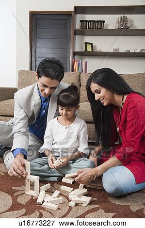 Stock Photo - Girl playing Jenga with her parents. Fotosearch