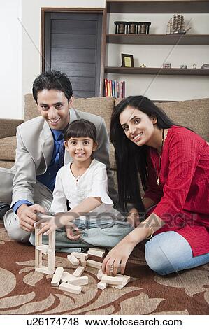 Girl playing Jenga with her parents View Large Photo Image Stock Photo - Girl playing Jenga with her parents. Fotosearch