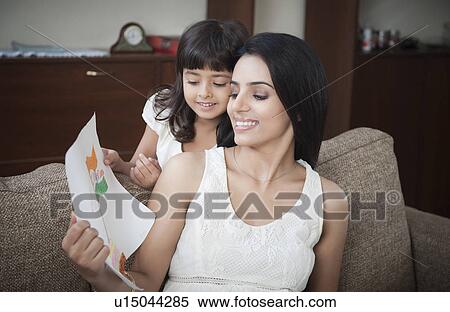 Stock Photography - Girl showing drawing of Indian flag to her mother. Fotosearch