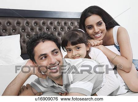 Girl smiling with her parents View Large Photo Image Stock Photograph - Girl smiling with her parents. Fotosearch