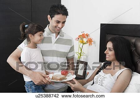 Girl with her father giving breakfast to her mother View Large Photo Image Stock Image - Girl with her father giving breakfast to her mother. Fotosearch