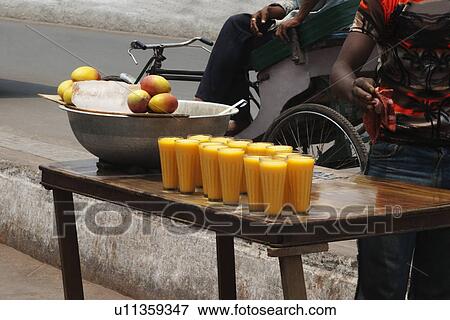 Stock Photo - Glasses of mango shake at a market stall, New Delhi, India. Fotosearch