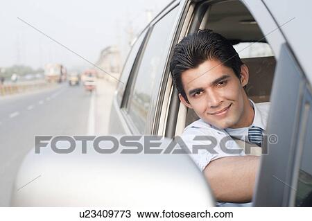 Stock Image - Happy businessman driving a car, Gurgaon, Haryana, India. Fotosearch