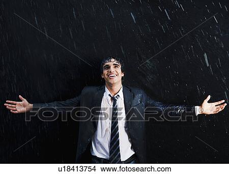 Picture - Happy businessman enjoying in the rain. Fotosearch