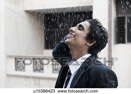 Happy businessman enjoying in the rain View Large Photo Image Stock Image - Happy businessman enjoying in the rain. Fotosearch