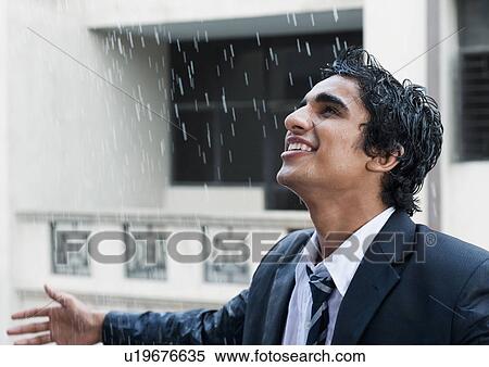 Stock Photography - Happy businessman enjoying in the rain. Fotosearch