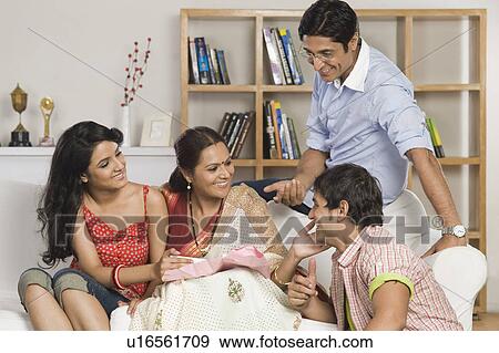 Stock Photo - Happy family sitting on a couch in a living room. Fotosearch