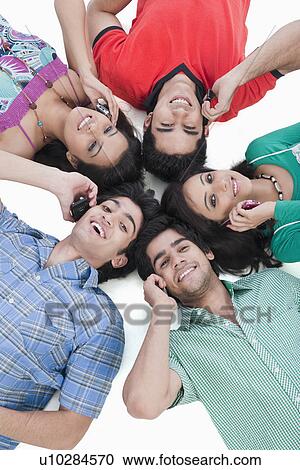 High angle view of friends talking on mobile phones View Large Photo Image Stock Image - High angle view of friends talking on mobile phones. Fotosearch